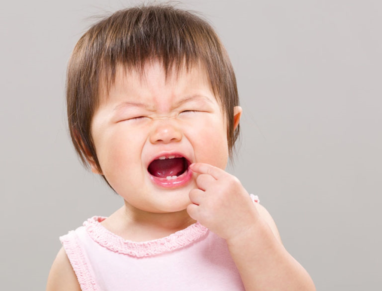Боль во рту после еды. Ребенок с высунутым языком.