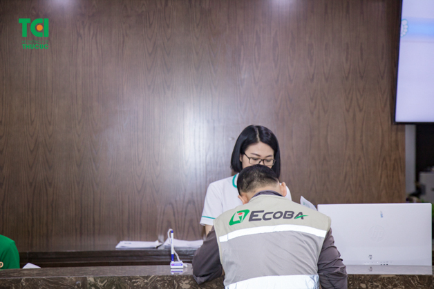 Nhân viên lao động Ecoba được nhân viên lễ tân hướng dẫn điền thông tin vào hồ sơ khám bệnh