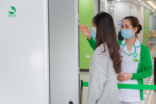 Người bệnh được đo thân nhiệt trước khi vào thăm khám