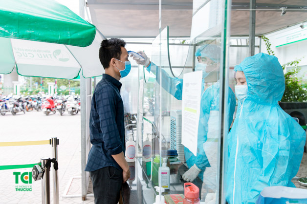 Người bệnh được đo thân nhiệt trước khi vào thăm khám