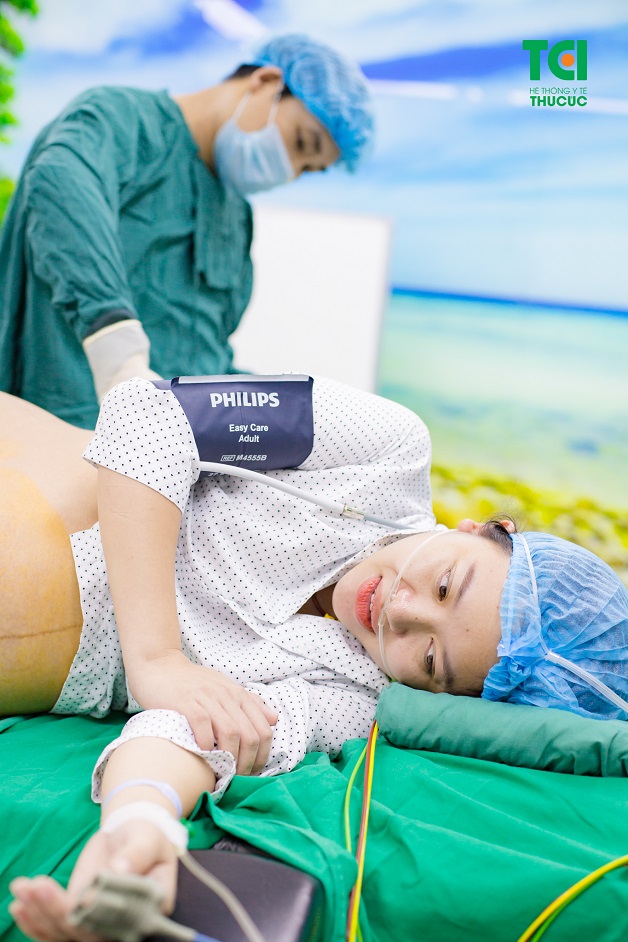 Được các bác sĩ đang gây tê tủy sống để chuẩn bị cho ca mổ mà Khánh Chi vẫn rất xinh đẹp