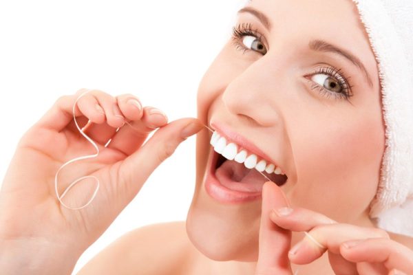 Sử dụng chỉ nha khoa để làm sạch thức ăn thừa, mảng bám ở trong kẽ răng thay cho tăm truyền thống