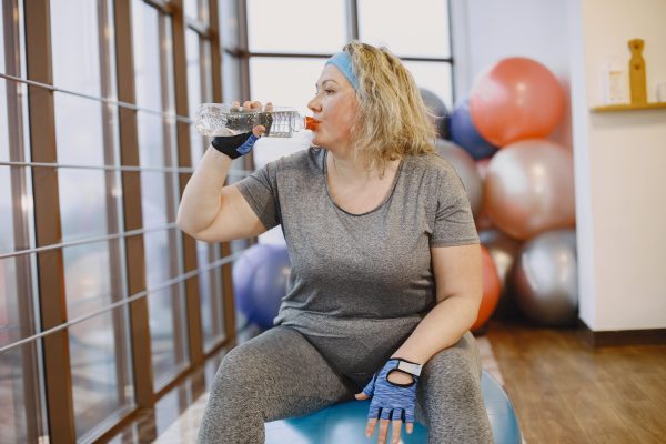 fat woman dieting fitness lady sitting fitball driking water min