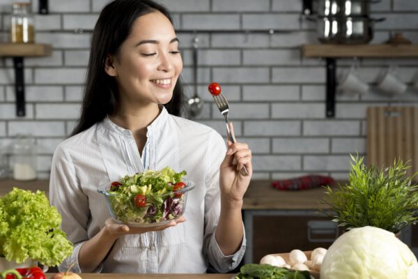 smiling asian woman with healthy salad kitchen min